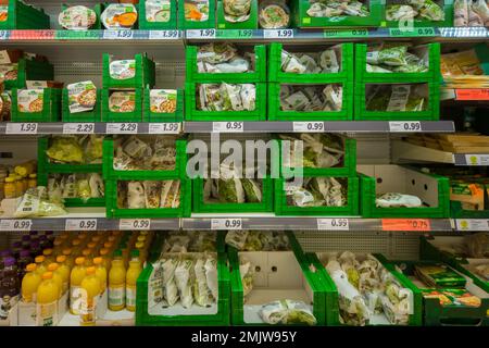 Italie - 28 janvier 2023: Boîtes de salades propres prêtes à être vendues en carton vert sur les étagères du supermarché italien Banque D'Images