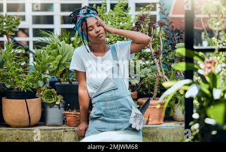 Femme fatiguée, jardinière ou noire avec maux de tête, stress ou épuisement après avoir nettoyé les plantes ou les fleurs sales. Jardinage, fatigue ou fatigue de la fille épuisée de repos Banque D'Images