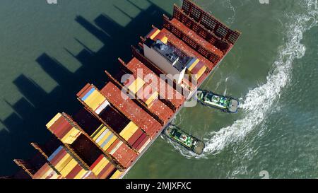 Qingdao. 27th janvier 2023. Cette photo aérienne prise le 27 janvier 2023 montre un bateau à conteneurs qui accostage au terminal de conteneurs de Qianwan du port de Qingdao avec l'aide de remorqueurs dans la province de Shandong, en Chine orientale. Credit: Li Ziheng/Xinhua/Alay Live News Banque D'Images