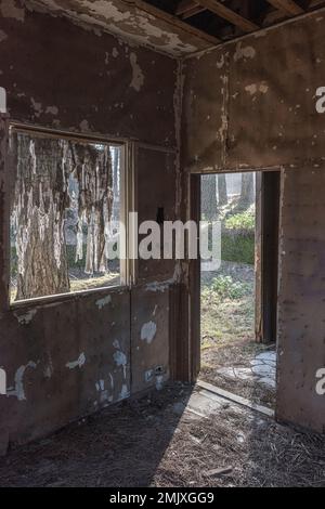 Chute de neige, vue de l'intérieur d'une chambre vide et abandonnée dans une ancienne station de ski abandonnée dans les bois sur l'Etna, Sicile, Italie Banque D'Images