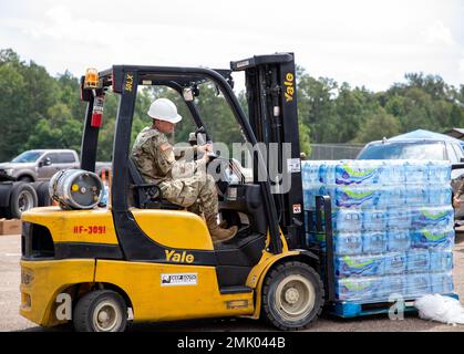 Un soldat, commandant de 66th troupes, de la Garde nationale de l'armée du Mississippi, distribue de l'eau avec un chariot élévateur à l'école moyenne Thomas Cardozo à Jackson, Mississippi, le 2 septembre 2022. Près de 600 gardes nationaux du Mississippi ont été établis sur sept sites à travers Jackson pour permettre aux gens de recueillir de l'eau en bouteille, de l'assainisseur pour les mains et de l'eau non potable dans des camions de buffles d'eau. Banque D'Images