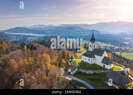 Église de Sternberg et cimetière idyllique à Wernberg, Carinthie, Autriche en automne avec vue sur le lac Wörthersee en arrière-plan. Banque D'Images