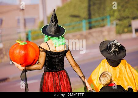 Portrait de près de l'arrière de la mère, les enfants en costumes d'Halloween Banque D'Images