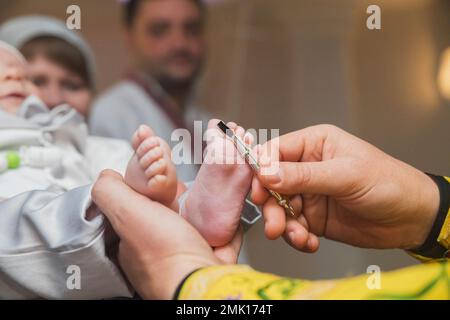 Le prêtre exécute la cérémonie d'onction du bébé Banque D'Images