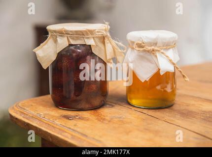 Pots de confiture de fraises et de miel sur une table en bois Banque D'Images