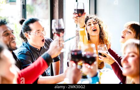 De jeunes amis multiculturels boivent et toaster du vin rouge au dîner - des gens heureux ivres s'amusent ensemble au restaurant bar de la cave de vinification Banque D'Images