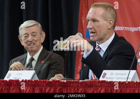 FILE - In this April 1, 2015, file photo, retired NBA basketball All-Star and St. John's alumnus Chris Mullin, holds a card given to him by his former coach Lou Carnesecca, left, that reads 'Peacock today, Feather duster tomorrow' during a news conference to announce his hiring as St. John's men's basketball coach, in New York. The card was given to Carnesecca from former St. John's coach Joe Lapchick. Mullin felt in his heart that it was time to move on from St. John’s. Mullin stepped down as coach of the school he starred at as a player in the 1980s earlier this month after four years on the