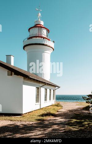 Danemark, Jutland, Djursland: Le phare rond blanc Sletterhage sur la péninsule d'Helganaes au soleil contre un ciel bleu et sans nuages. Banque D'Images