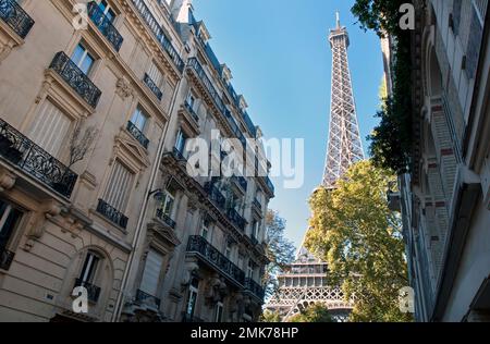 La Tour Eiffel s'élève derrière des bâtiments résidentiels ornés au bout de la rue de l'Université dans le 7th arrondissement de Paris. Banque D'Images