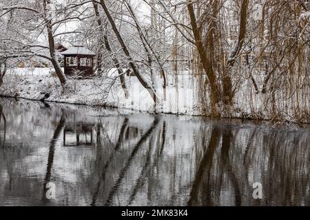 Un petit belvédère en bois dans les profondeurs d'une forêt d'hiver près d'un ruisseau de montagne froid et noyés marchent le long de lui, grimpant d'une vallée forestière. Banque D'Images