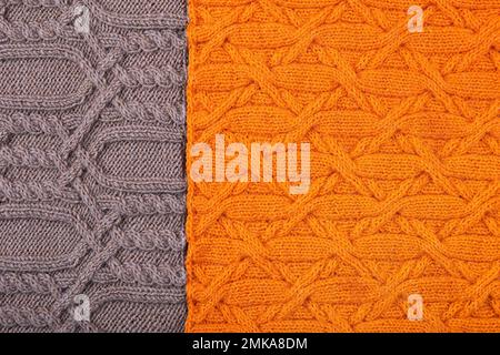 Arrière-plan tricoté orange et marron. Grand tissu tricoté avec un motif. Gros plan d'une couverture tricotée. Banque D'Images