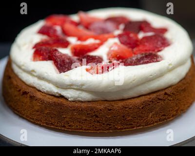 chef pâtissier confiserie un gâteau dépoli de 3 couches de sol farci de fraises et de crème au beurre fouetté. Structure du gâteau avant la décoration Banque D'Images