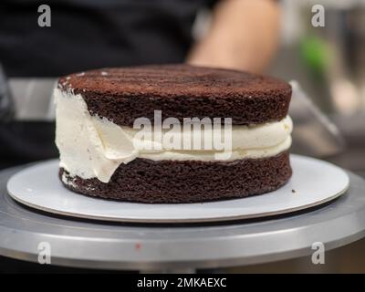 chef pâtissier confiserie un gâteau dépoli de 3 couches de sol farci de fraises, de bleuets et de crème au beurre fouetté. Structure de gâteau bef Banque D'Images