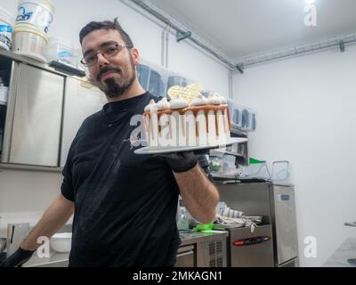 pâtissière de chef finissant des gâteaux dépoli au caramel salé avec des meringues et un surmatelas fait main au coeur doré chocolat Banque D'Images