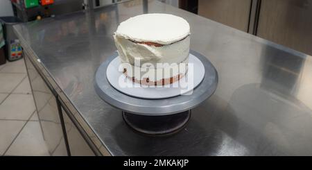 chef pâtissier confiserie un gâteau dépoli de 3 couches de sol farci de fraises, de bleuets et de crème au beurre fouetté. Structure de gâteau bef Banque D'Images