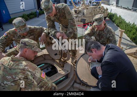 L'honorable Doulgas Bush, secrétaire adjoint de l'armée américaine pour l'acquisition, la logistique, Et la technologie, regarde à l'intérieur d'un char de bataille de l'armée américaine M1A2 Abrams avec le remeur d'armure de chars, affecté à la compagnie Bravo, 1st Bataillon, 68 Armored Regiment, 3rd Armored Brigade combat Team, 4th Infantry Division, lors de l'exposition annuelle de l'industrie de défense internationale 30th à Kielce, Pologne, le 7 septembre 2022. Des salons commerciaux comme le MPSO offrent une occasion unique au ministère de la Défense des États-Unis et à l'industrie de la défense de s'engager avec des alliés et des partenaires, et de démontrer certaines de ses capacités. Banque D'Images