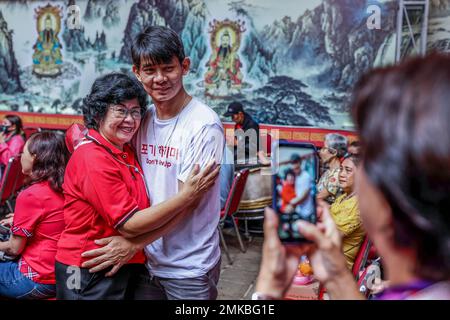 Une femme hante son enfant avant le festival Cap Go meh, marquant la fin des célébrations du nouvel an lunaire chinois au temple de Dhanagun. Alors que les célébrations se terminent, les Indonésiens chinois enseignent aux enfants de laver les pieds de leur mère pour exprimer leur gratitude. ''les pieds des parents de lavage'' est une tradition chinoise depuis des milliers d'années. C'est pour respecter la diversité dans la façon dont les autres célèbrent (fête des mères). Banque D'Images