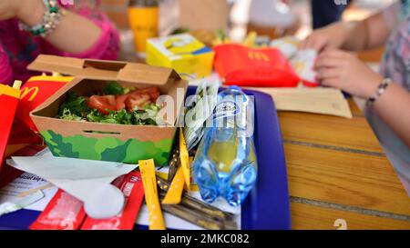 Police, Pologne. 15 août 2022. Les jeunes femmes avec de la nourriture servie sur un plateau dans un restaurant McDonald's. Banque D'Images