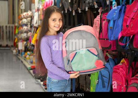 Petite fille d'école avec sac à dos dans le supermarché Banque D'Images