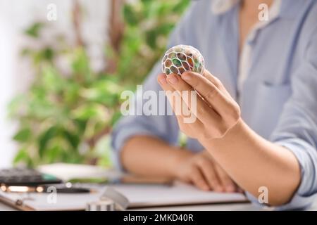 Femme avec de la chaux colorée dans le bureau, à proximité. Jouet antistress Banque D'Images