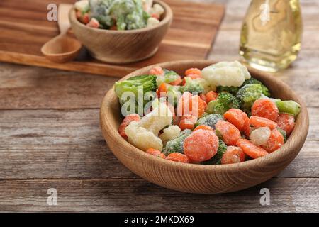 Savoureux mélange de légumes surgelés sur table en bois, en gros plan Banque D'Images