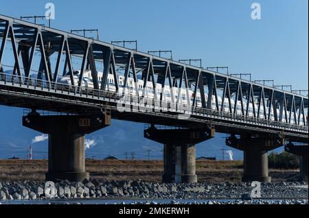 Un train JR Central N700S sur la ligne Shinkansen de Tokaido traverse un pont au-dessus du fleuve Fuji (Fujikawa) dans la préfecture de Shizuoka, au Japon. Banque D'Images