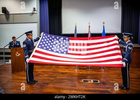 Les aviateurs du garde d'honneur du Groupe de la base aérienne 422d tiennent un drapeau à la position de table lors d'une cérémonie de retraite 9/11 à la RAF Broughton, Angleterre, le 9 septembre 2022. Des aviateurs et des invités ont participé à la cérémonie pour rendre hommage à ceux qui ont perdu la vie pendant les attaques terroristes du 11 septembre. Banque D'Images