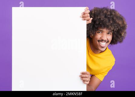 Homme africain souriant avec des cheveux bouclés tenant un panneau vierge Banque D'Images