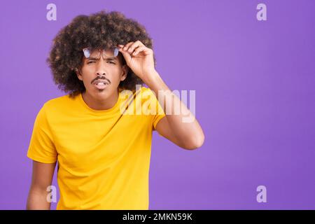 Homme africain qui a pris ses lunettes pour voir loin Banque D'Images