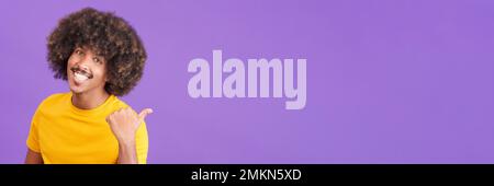 Homme africain souriant à la caméra et pointant vers le côté Banque D'Images