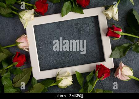 Roses rouges et blanches, cadre photo pour la Saint-Valentin, proposition de mariage, anniversaire ou mariage. Flat Lay Love fleurs avec espace de copie. Banque D'Images