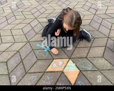 Petite fille dessin avec une craie à l'extérieur. Activités de loisirs pour les enfants concept Banque D'Images