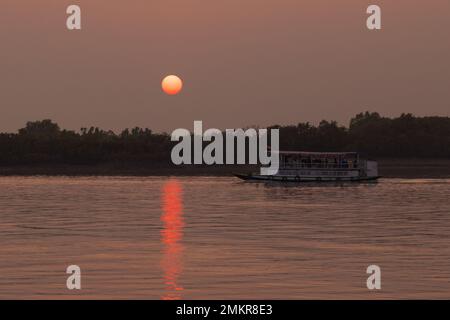 Un bateau touristique naviguant dans la rivière au crépuscule (Sunderbans, Bengale-Occidental, Inde) Banque D'Images