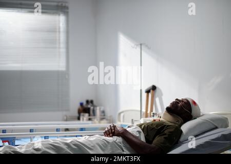 Militaire malade se reposant dans la salle d'hôpital après une chirurgie de la tête Banque D'Images