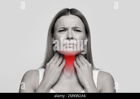 Femme souffrant de maux de gorge, de toucher son cou Banque D'Images