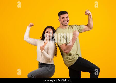Joyeux et excités jeune couple arabe dans décontracté faire le geste de la réussite et de la victoire, réjouissez-vous ensemble Banque D'Images