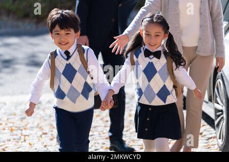 Un jeune couple vient chercher les enfants de l'école Banque D'Images