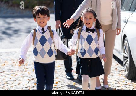 Un jeune couple vient chercher les enfants de l'école Banque D'Images