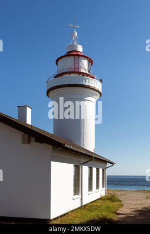 Danemark, Jutland, Djursland: Le phare rond blanc Sletterhage sur la péninsule d'Helganaes au soleil contre un ciel bleu et sans nuages. Banque D'Images