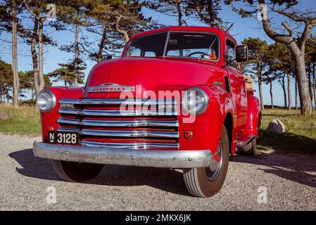 Vue frontale d'une vieille voiture classique rouge Chevrolet pick-up 3100 dans un parking sur la côte du Danemark, Djursland, Jutland. Banque D'Images