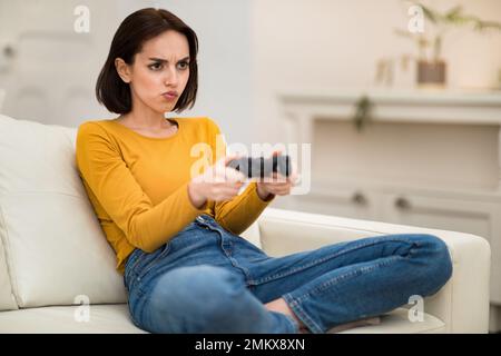 Jeune femme trempée à chaud jouant à des jeux vidéo à la maison Banque D'Images