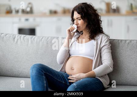 Femme enceinte malade souffrant de rhume ou de grippe pendant qu'elle est assise à la maison Banque D'Images