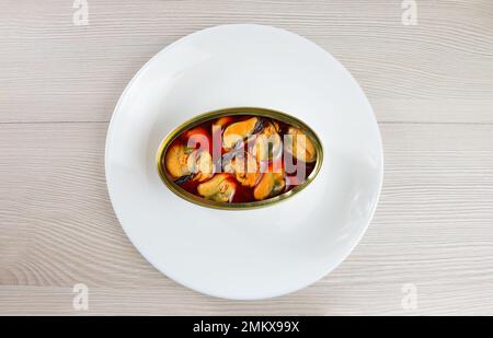 Photo en grand angle d'une délicieuse boîte de moules sur une assiette sur une table en bois rustique Banque D'Images