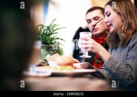 Heureux couple eating fast food burger et döner dans fast food cafe Banque D'Images