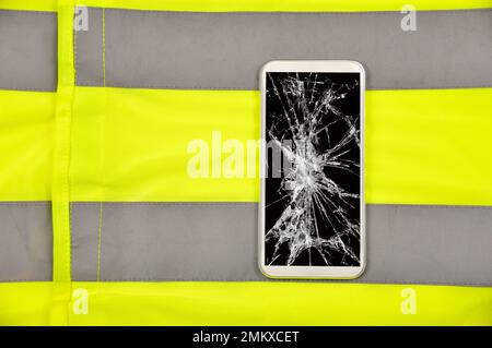 téléphone cassé avec chemise jaune sur le concept d'appel d'urgence en cas d'accident Banque D'Images