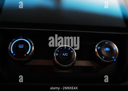 Le processus de choix de la climatisation dans la voiture. Homme réglant la température de l'air conditionné de la voiture. Intérieur de voiture moderne Banque D'Images