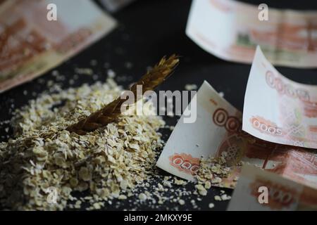 Le concept du coût du grain. 5000 roubles de billets autour d'une poignée de grain de terre. La faim dans le monde. Banque D'Images