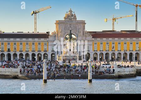 Les touristes et les habitants de la région apprécient la chaude soirée d'été sur la rive du Tage. Coucher de soleil sur Praça do Comércio, place du Commerce à Lisbonne, Portugal. Banque D'Images