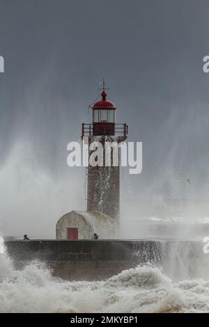 Porto, Portugal - 7 février 2016: Rivière Douro bouche vieux phare pendant la tempête voyant les gens s'éloigner des vagues de la mer. Banque D'Images