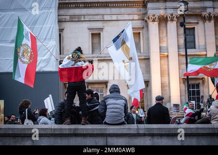 Les manifestants brandisquent les drapeaux iraniens lors de la Révolution iranienne de ìSupport !Î protestation. Les manifestants se sont rassemblés à Trafalgar Square à Londres pour soutenir les femmes en Iran, alors qu'elles se battaient pour leur liberté. Après la mort d'une femme de 22 ans en Iran, Mahsa Amini, aux mains de la « police de la personnalité » pour ne pas couvrir ses cheveux correctement, les femmes iraniennes sont descendues dans les rues pour réclamer leur liberté. En Iran, les femmes sont contraintes de respecter les lois obligatoires sur le voile et peuvent faire face à la détention, au harcèlement et à la torture pour ne pas avoir respecté le code vestimentaire de manière adéquate. Banque D'Images